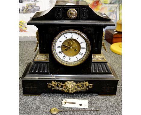 A 19th Century French marble mantel clock Roman numerals, twin winding holes flanked by masks of a young lady, hand chased gi