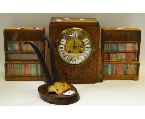 A pair of miniature bookcases; a pair of mounted antlers; an oak early 20th Century mantel clock brass and enamel dial, Roman