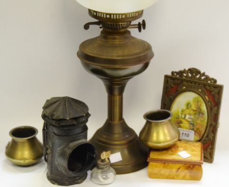 An early 20th Century oil lamp; a paraffin light; a brass easel photograph frame; prints; etc