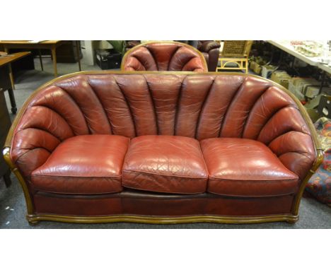 A 20th Century ox blood red lounge suite, comprising of a three seater sofa a conforming tub  chair (2)