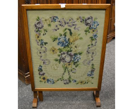 An early 20th Century oak metamorphic tapestry fire screen with embroidered floral motif and border c 1930