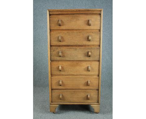 A mid century light oak tall chest, raised on later casters. H.129 W.61 D.41cm. 