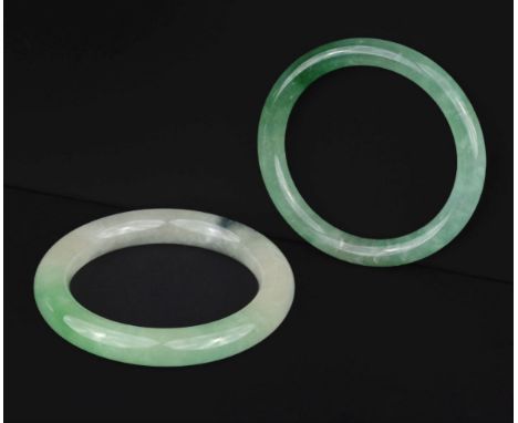 * Jade. A Chinese jade bangle, apple green colour, 8 cm diameter, together with a similar bangle, 7 cm diameterQTY: (2)