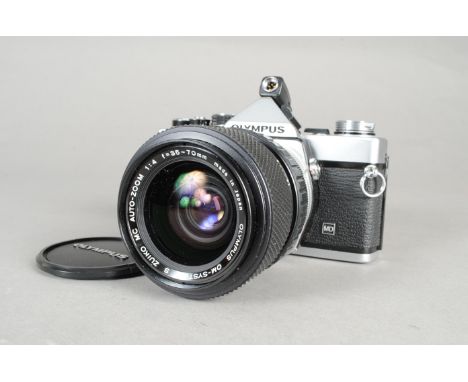 An Olympus OM-2N MD SLR Camera, chrome, serial no 919886, shutter working, body VG, slight marks to top and bottom plates, pa