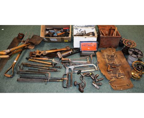 A large assortment of old tools, comprising of saws, forks, spades, hand drills, hammers, mallets, pumps, clamps, spanners, w