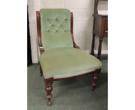 A Victorian mahogany framed button back chair upholstered in light green plush.