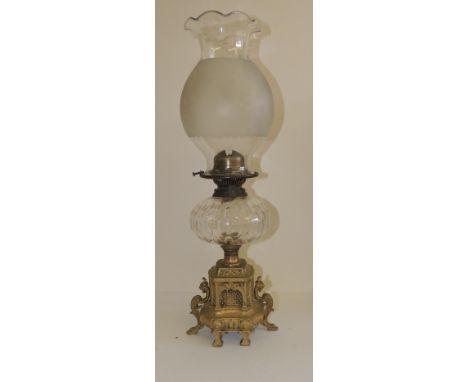 A 19th Century oil lamp with shaped, frosted shade, faceted glass reservoir and decorative gilt metal base with monopod side 