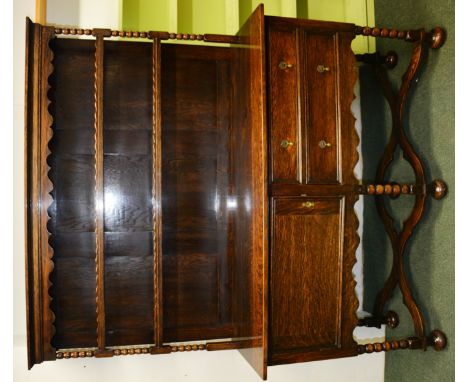 Early 20th Century oak dresser with open shelf top, the base fitted with two drawers and cupboard on bobbin turned supports. 
