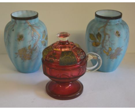 A 19th Century cranberry glass cup and cover, the faceted cover with gilt painted decoration, 15cms high together with a pair