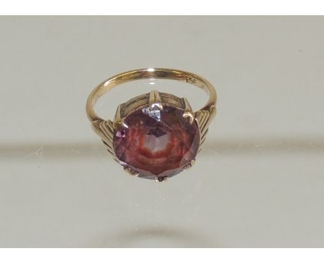 A 9ct gold dress ring, set with a circular, faceted violet, red stone, possibly Fluorite. Ring size K. 