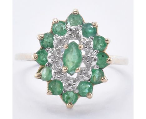 A 9ct gold emerald and diamond cluster ring. The ring having a central marquise cut emerald surrounded by a halo of eight ill