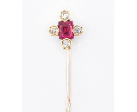 A gold ruby and diamond stick pin. The pin having a finial set with a rectangular cut ruby and four round cut diamonds. Ruby 