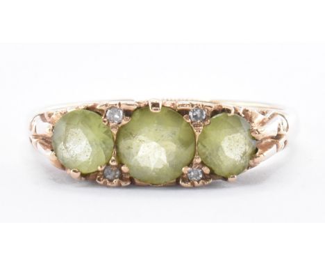 A hallmarked 9ct gold three stone peridot ring. The ring with three round cut peridot stones within a gypsy setting. Assay ma