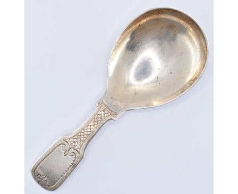 A Victorian late 19th century hallmarked silver caddy spoon. The spoon having engraved fleur de lis and hatched detailing to 