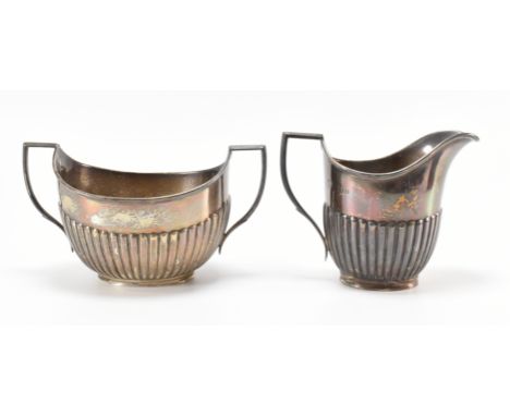 An early 20th Century silver hallmarked William Hutton &amp; sons silver creamer jug and sugar bowl having angular handles an