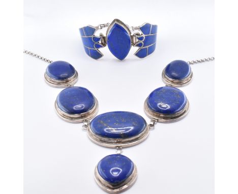 A silver collar necklace and bracelet suit. The necklace with five oval lapis lazuli panels with a pear shaped drop below (ma