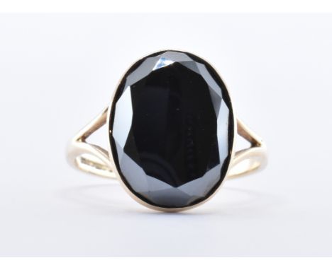 A hallmarked 9ct gold and mirror quartz ring. The ring with a central hematite stone within a rub over setting. Hallmarked fo