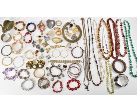 A collection of vintage costume jewellery to include bangle and beaded bracelets, mid Century brooches, beaded and chain neck