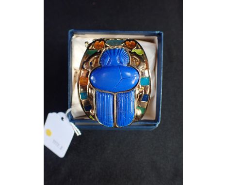 A 1970s EGYPTIAN STYLE BANGLE BY THOMAS FATTORINI Ltd with large imitation scarab motif and enamels, on gilt metal (made at t