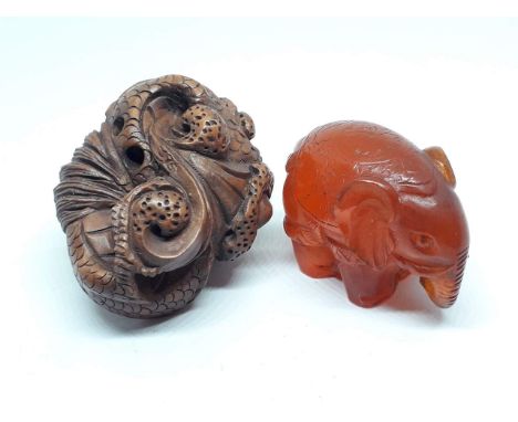 A Japanese amber netsuke and a carved wooden netsuke. 