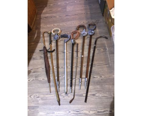 A collection of vintage shooting sticks, a vintage riding crop and a vintage umbrella etc. 