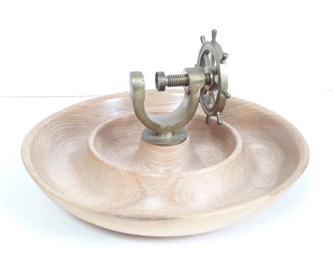 A novelty nut cracker modelled as a ship's wheel mounted on turned wooden base. 