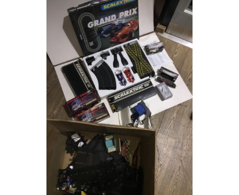 A large box containing scalextric track, accessories, racing trucks and a grand-prix set 