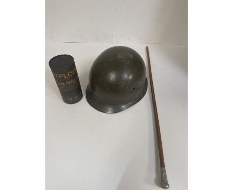 A Royal Marines swagger stick, German para hemet and an explosives container 