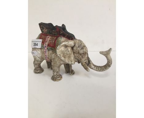 A cast iron money box in the form of an elephant, tail operates trunk to feed coins 