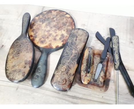 A vintage tortoiseshell dressing table set inscribed with Chinese style decoration. 