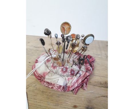 A pin cushion containing various stickpins including one 9ct gold etc. 