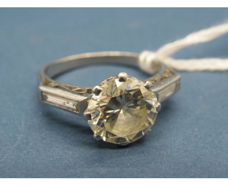 A Large Single Stone Diamond Ring, the (8mm) old brilliant cut stone claw set between diamond set shoulders, stamped "Plat". 