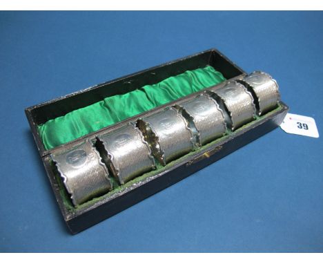 A Set of Six Hallmarked Silver Napkin Rings, E.S. Barnsley & Co Ltd, Birmingham 1915, each allover engine turned, with shaped