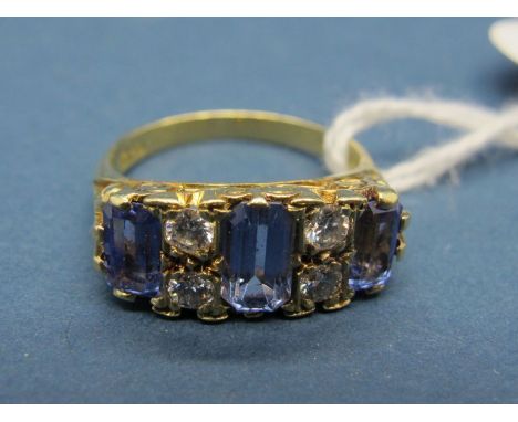 An 18ct Gold Tanzanite and Diamond Set Dress Ring, claw set with three emerald cut tanzanites, with brilliant cut diamond spa