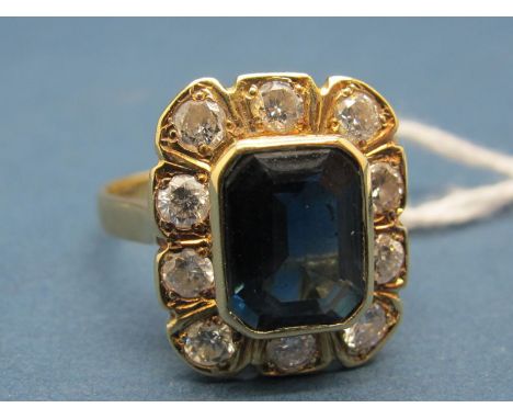 A Sapphire and Diamond Cluster Ring, rectangular collet set to the centre, within shaped border of brilliant cut diamonds, st