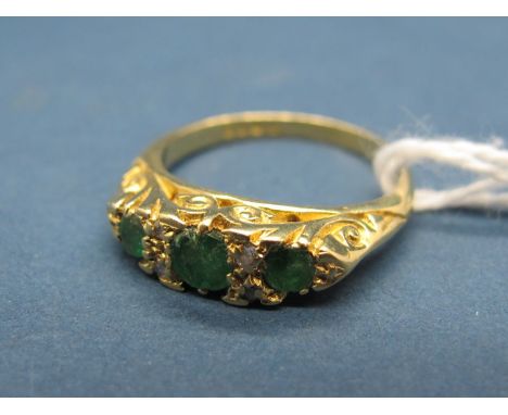 An 18ct Gold Emerald and Diamond Set Ring, of graduated design with claw set highlights, within scroll carved setting. 