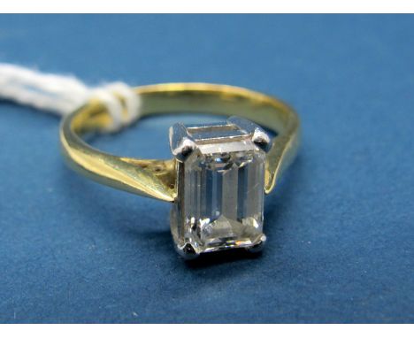 An 18ct Gold Emerald Cut Single Stone Diamond Ring, the 7x5mm stone four claw set between plain shoulders.