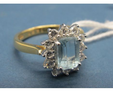 An 18ct Gold Aquamarine and Diamond Cluster Ring, rectangular set to the centre, within claw set border. 