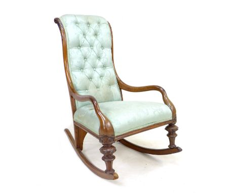A Victorian mahogany rocking chair, upholstered in button back fabric, with carved decoration to the frame, 60 by 83 by 102cm