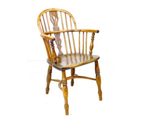 A Georgian oak and yew Windsor armchair, low rounded back with pierced splat and stick supports, shaped seat raised on turned