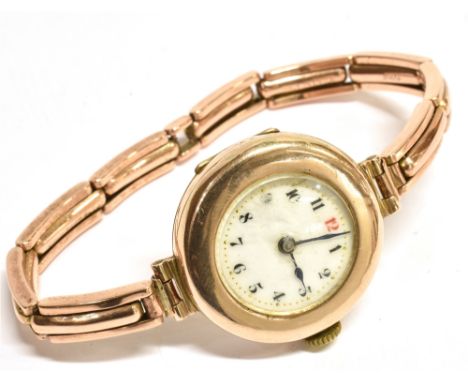 A 9CT ROSE GOLD CASE LADIES VINTAGE WRISTWATCH anonymous white enamel dial, black Arabic numerals (Red 12) and batons, gilt a