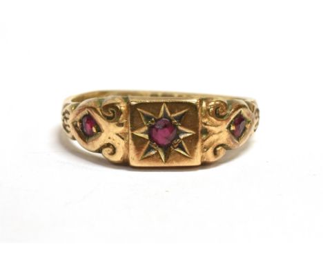 A VINTAGE 9CT GOLD RUBY GYPSY RING The ring set with three round cut rubies, the central ruby star set, engraved pattern to t