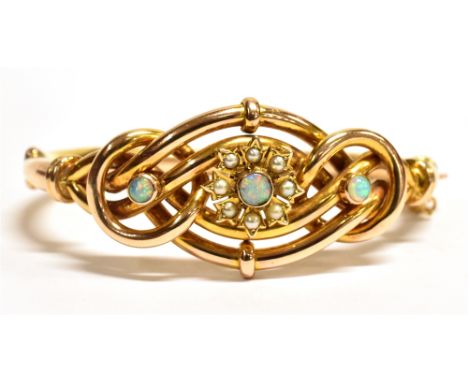 A VINTAGE 9CT GOLD OPAL AND SEED PEARL EVERLASTING BANGLE The bangle of hollow tube design, set with three round cut opals an