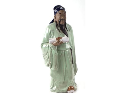 A large Chinese pottery figure of a scholar holding a scroll, 47cms high.