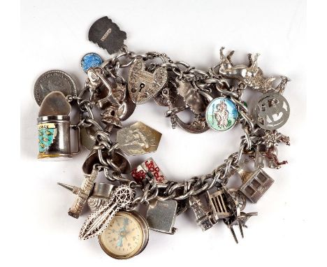 A silver padlock charm bracelet with approx 30 charms to include a compass, tankard, enamel shield for Arundel and others and