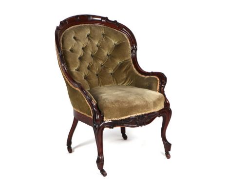 A Victorian walnut framed upholstered button backed tub chair.