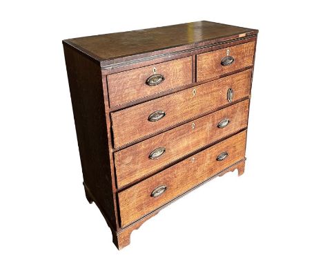 A 19th century oak chest crossbanded in mahogany with an arrangement of two short and three graduated long drawers, on bracke