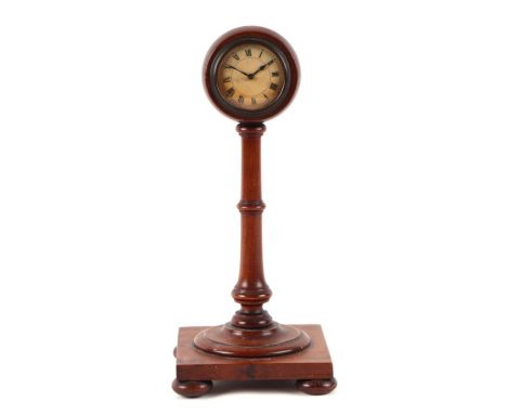 An Edwardian mantle clock, the white paper dial with Roman numerals, on a turned mahogany column and square base, 29cms high.