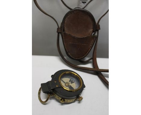 A WW1 military compass with leather case and shoulder strap. dated 1916. Compass by E R Watts &amp; Sons 