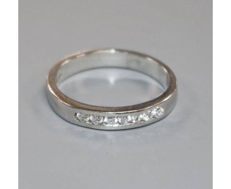 A modern 18ct white gold and seven stone diamond half hoop ring, size O.